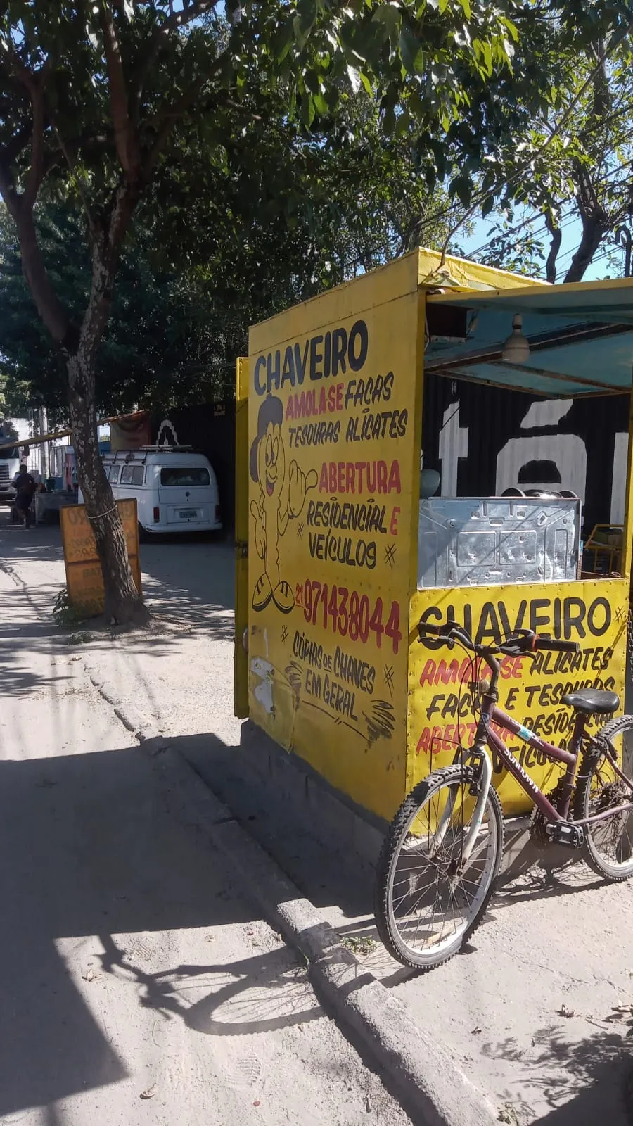 Lateral da banca do Chaveiro Marcos com o telefone e o serviço de cópias de chaves pintados